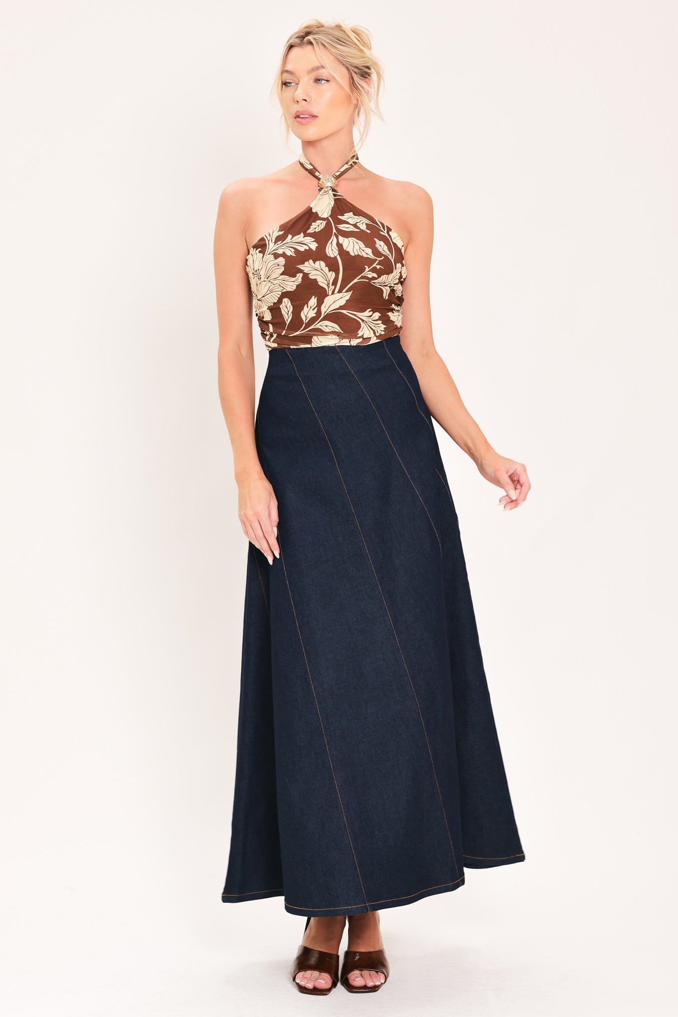 A dark navy blue denim maxi skirt with diagonal seam details, shown on a model | Flying Tomato