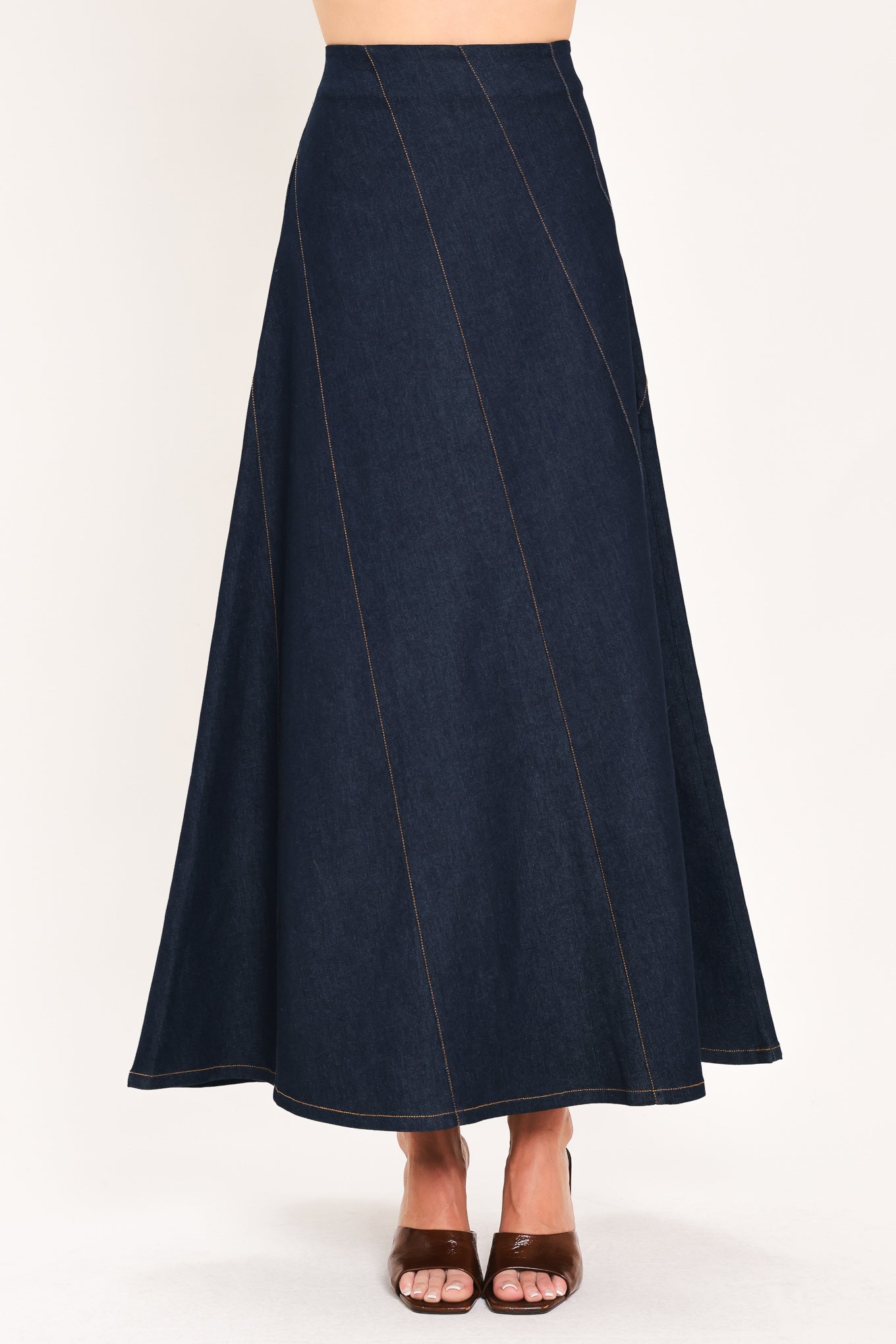 A dark navy blue denim maxi skirt with diagonal seam details, shown on a model | Flying Tomato