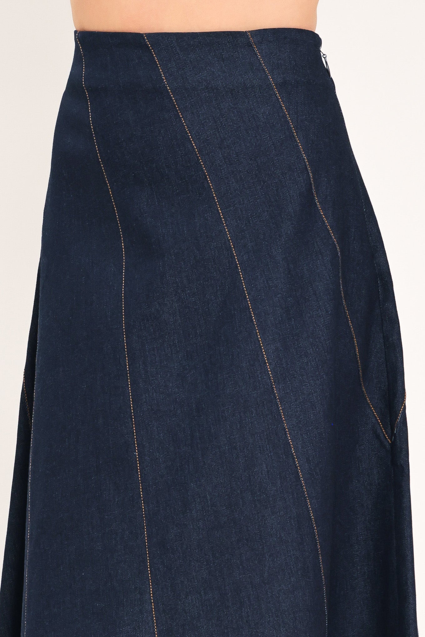 A dark navy blue denim maxi skirt with diagonal seam details, shown on a model | Flying Tomato