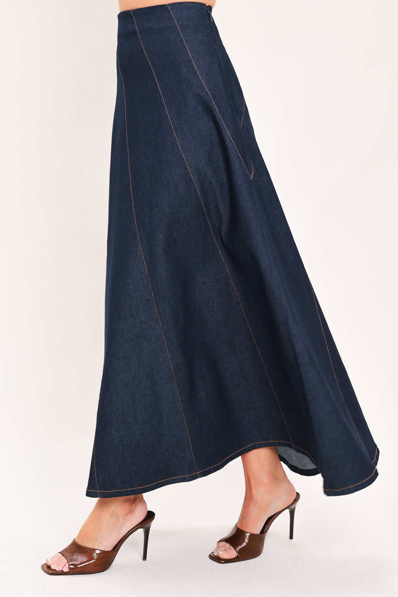A dark navy blue denim maxi skirt with diagonal seam details, shown on a model | Flying Tomato
