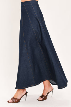 A dark navy blue denim maxi skirt with diagonal seam details, shown on a model | Flying Tomato
