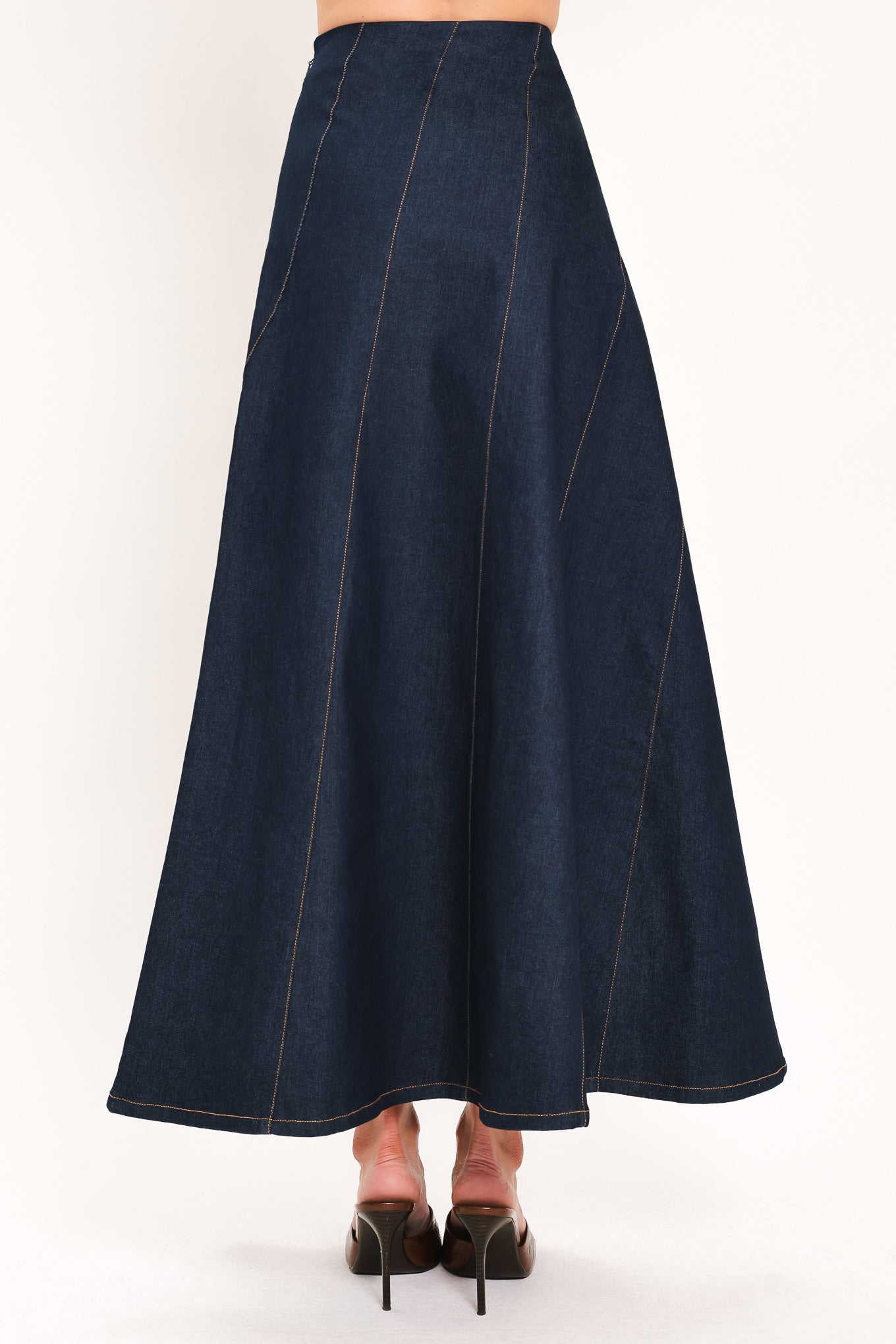 A dark navy blue denim maxi skirt with diagonal seam details, shown on a model | Flying Tomato