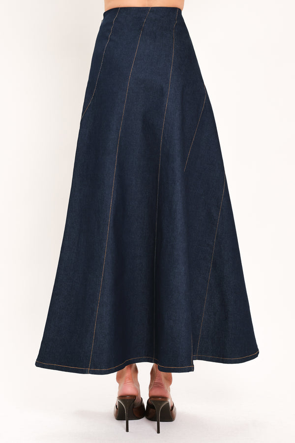 A dark navy blue denim maxi skirt with diagonal seam details, shown on a model | Flying Tomato