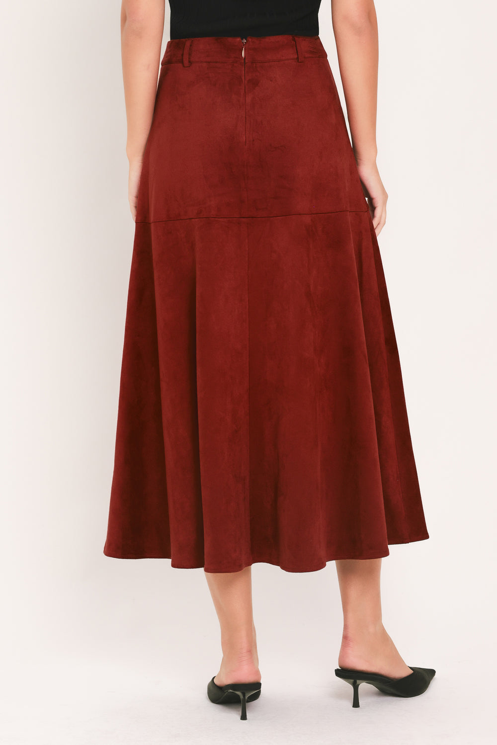 A brick colored suede midi skirt with a button-down front, flap pockets, and gold-tone button accents, shown on a model | Flying Tomato