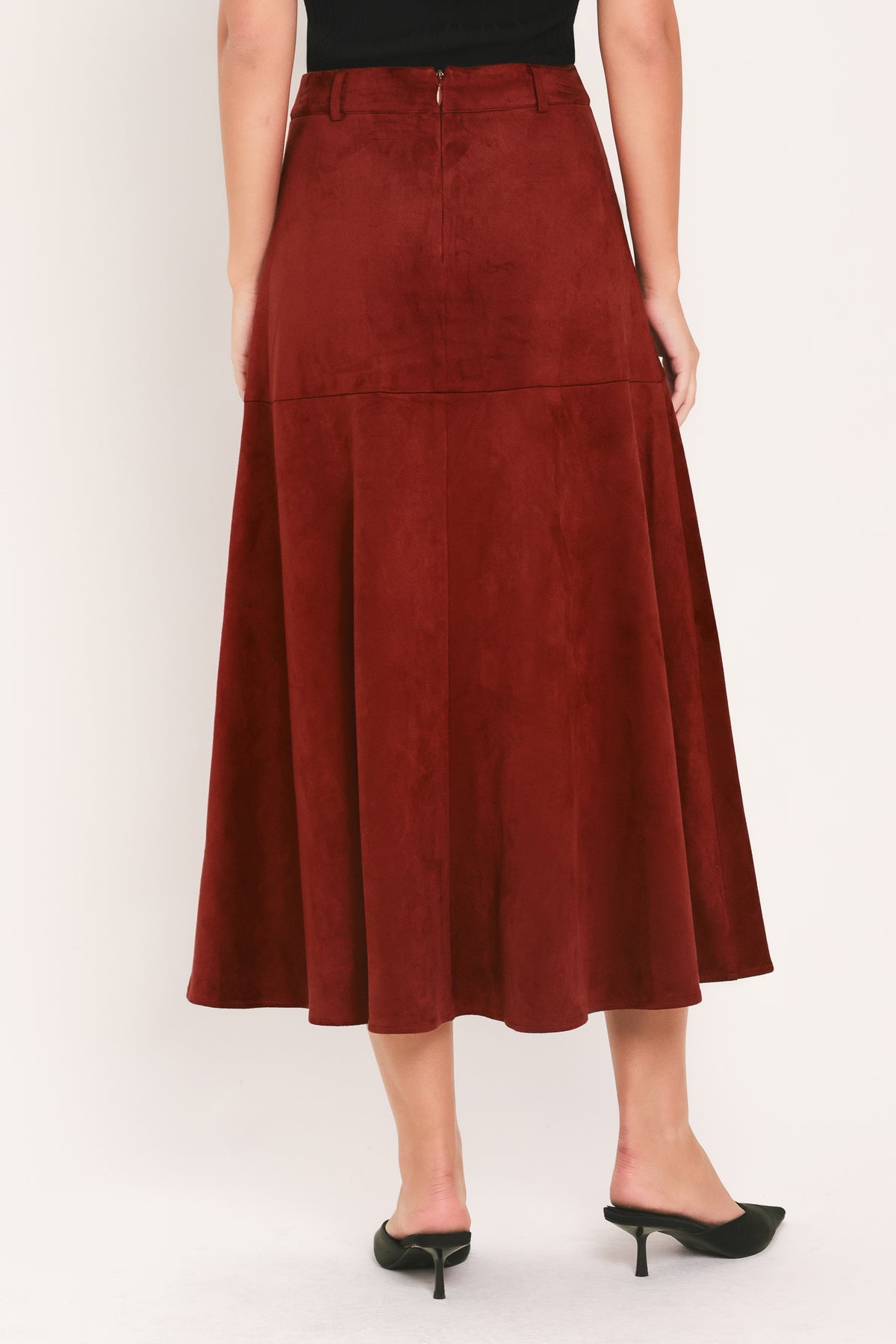 A brick colored suede midi skirt with a button-down front, flap pockets, and gold-tone button accents, shown on a model | Flying Tomato