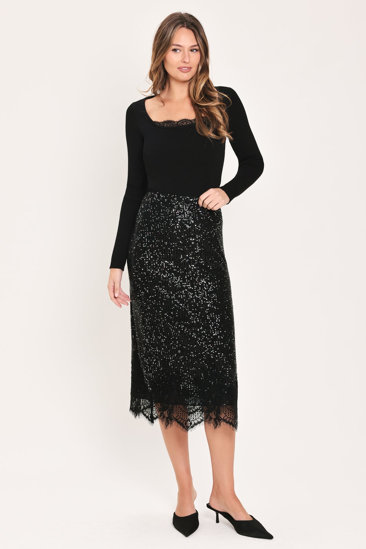 A woman modeling a black sequined midi skirt with a lace hem | Flying Tomato