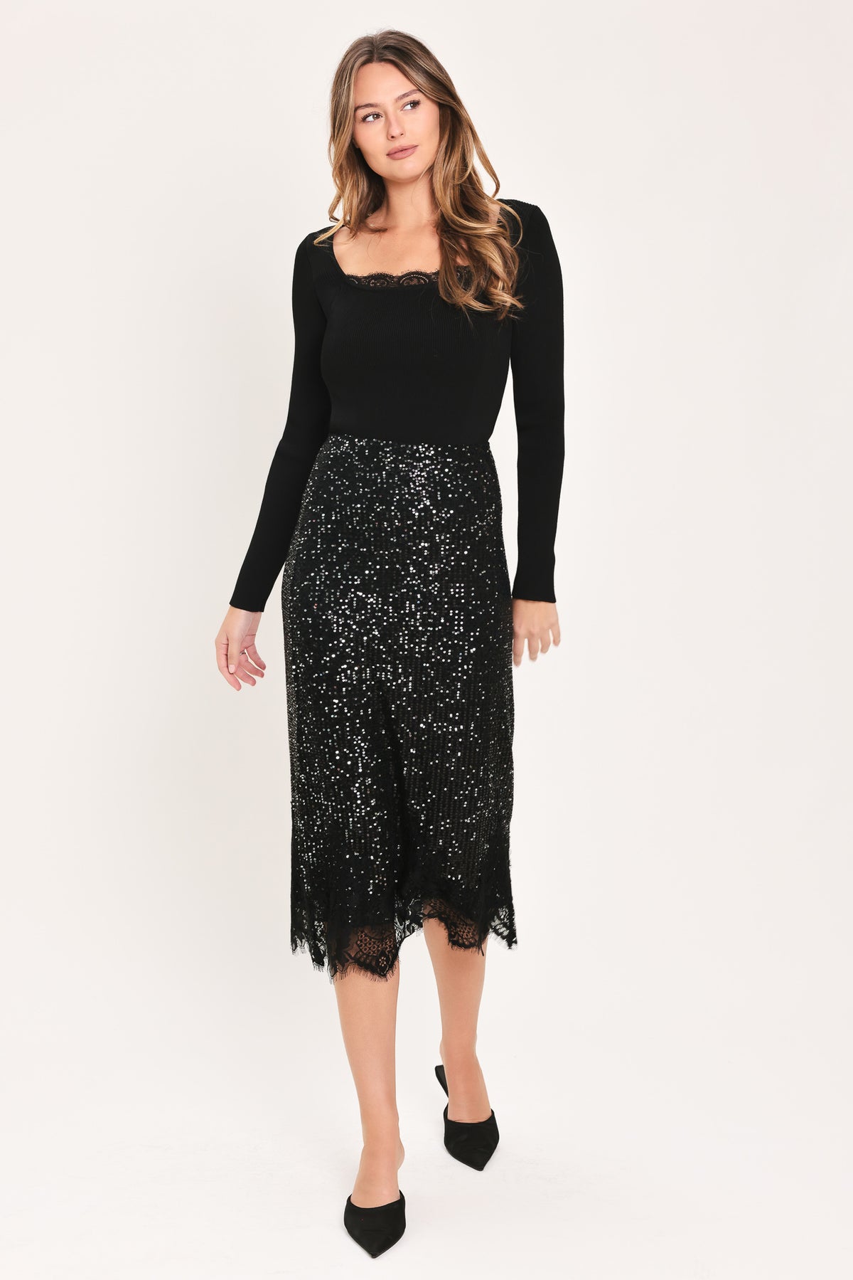 A woman modeling a black sequined midi skirt with a lace hem | Flying Tomato
