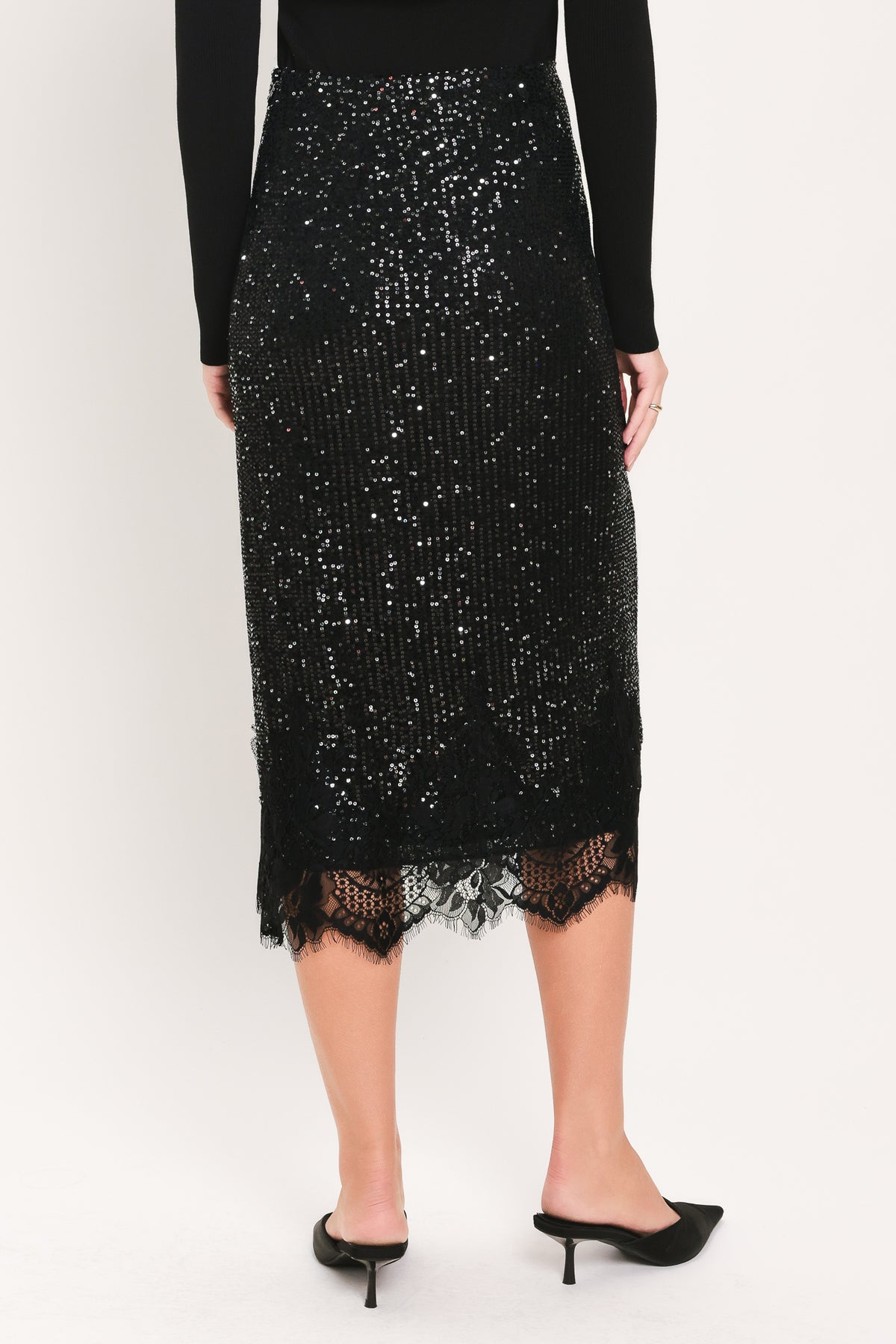 A woman modeling a black sequined midi skirt with a lace hem | Flying Tomato