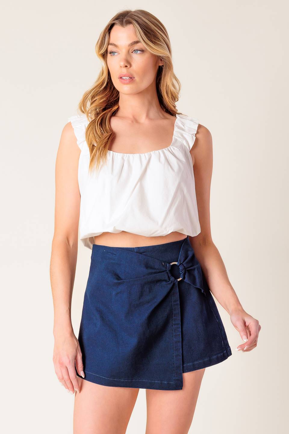 A solid dark blue woven skort featuring side O ring detail and side zipper closure.