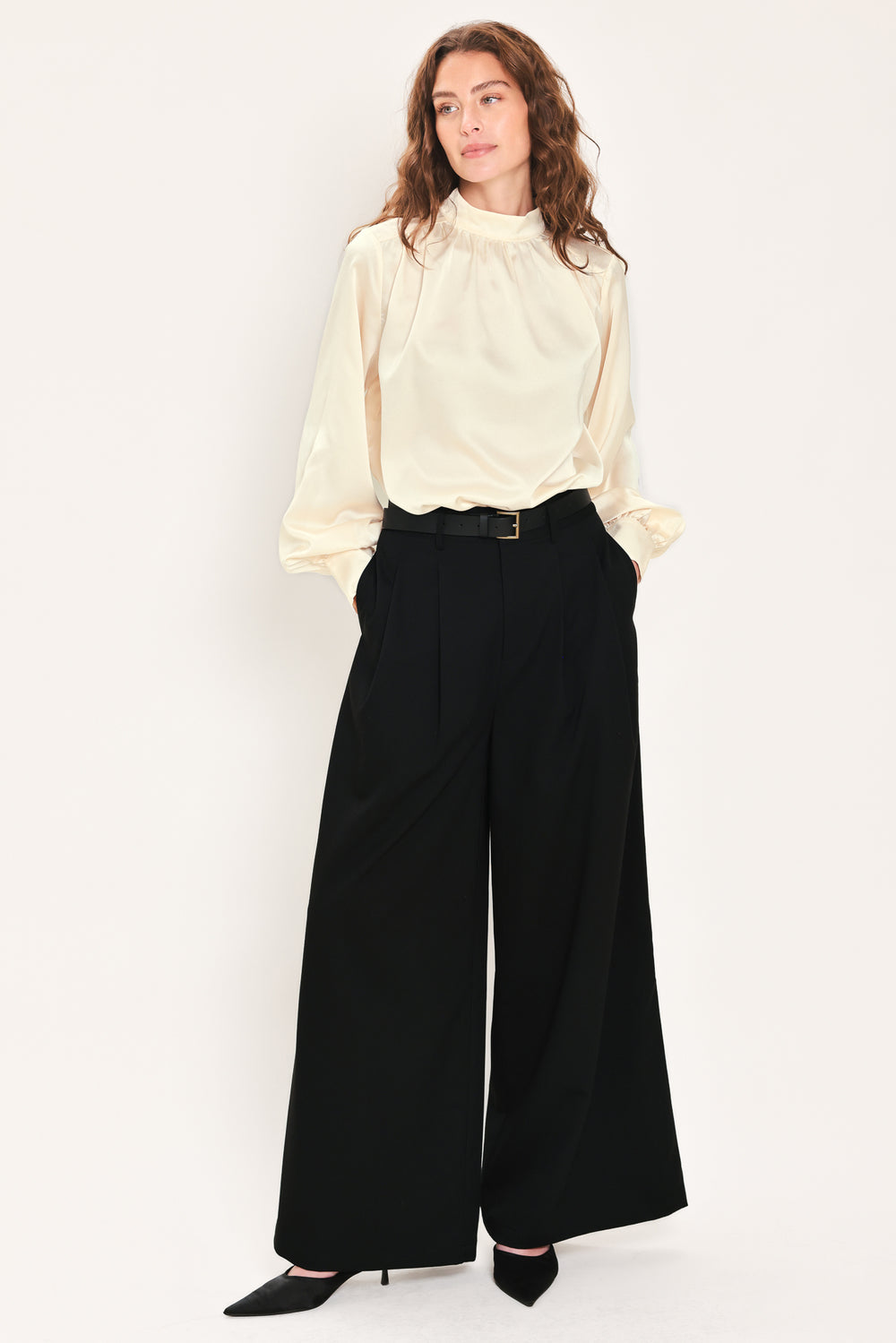 Woman wearing high-waisted, wide-leg trousers with pleats and coordinating belt | Flying Tomato