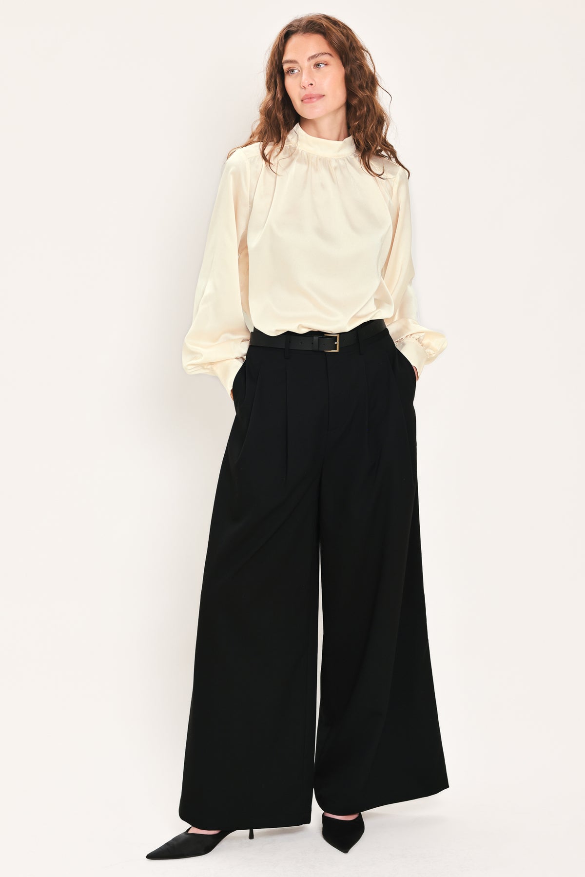 Woman wearing high-waisted, wide-leg trousers with pleats and coordinating belt | Flying Tomato