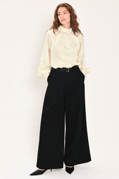 Woman wearing high-waisted, wide-leg trousers with pleats and coordinating belt | Flying Tomato