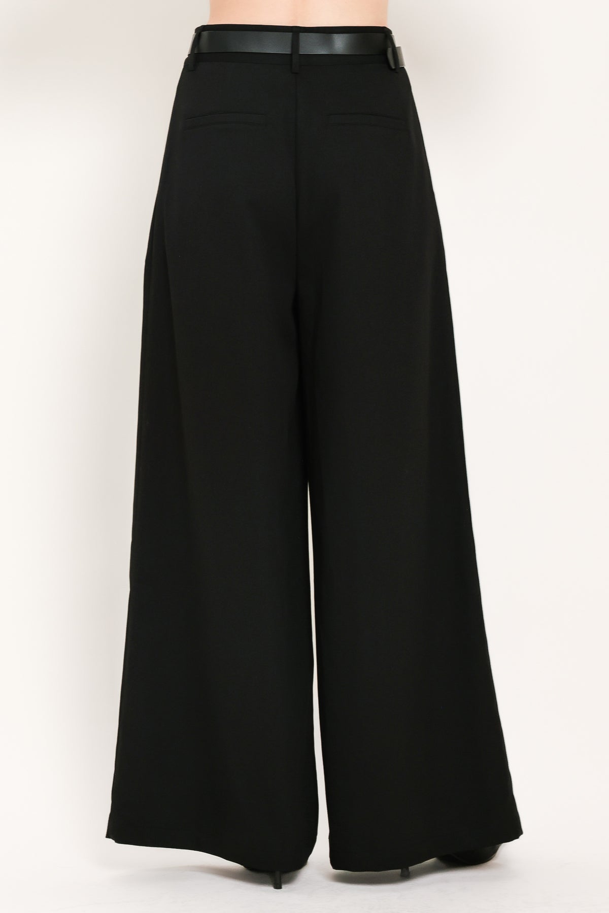 Woman wearing high-waisted, wide-leg trousers with pleats and coordinating belt | Flying Tomato