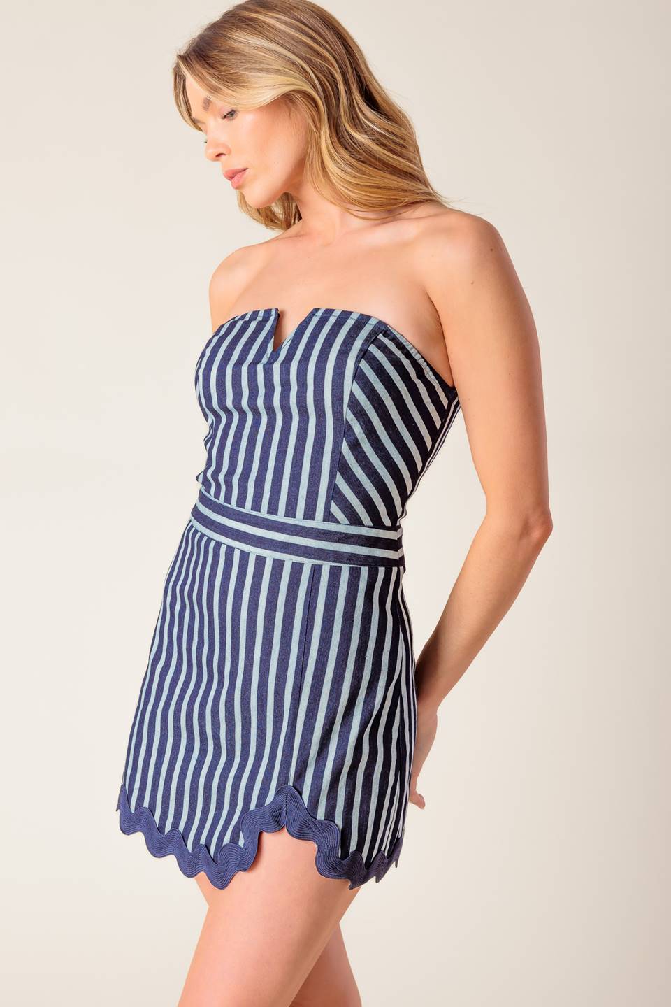 A striped woven skort romper featuring off shoulder neckline, ric rac ribbon hem and back zipper closure.