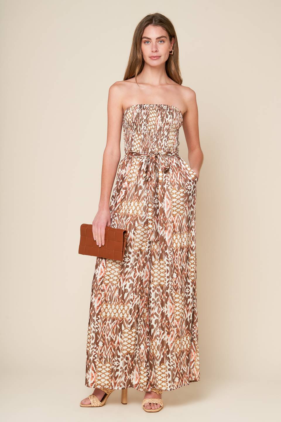 
A printed woven jumpsuit with a strapless, smocked bodice, self sash, and wide leg, perfect for a VACAY