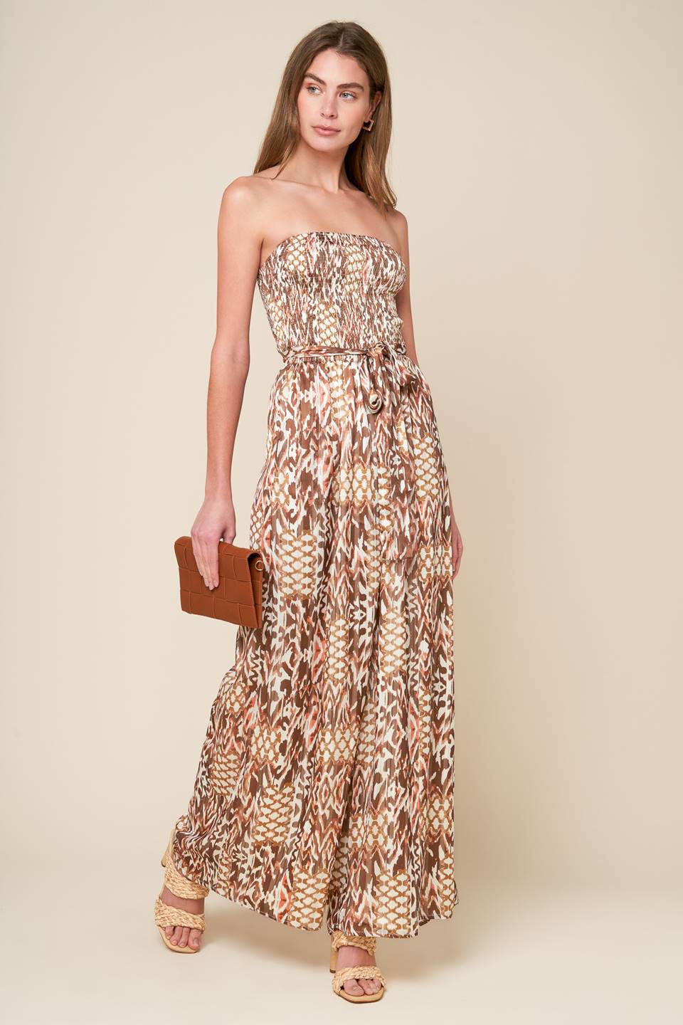 
A printed woven jumpsuit with a strapless, smocked bodice, self sash, and wide leg, perfect for a VACAY