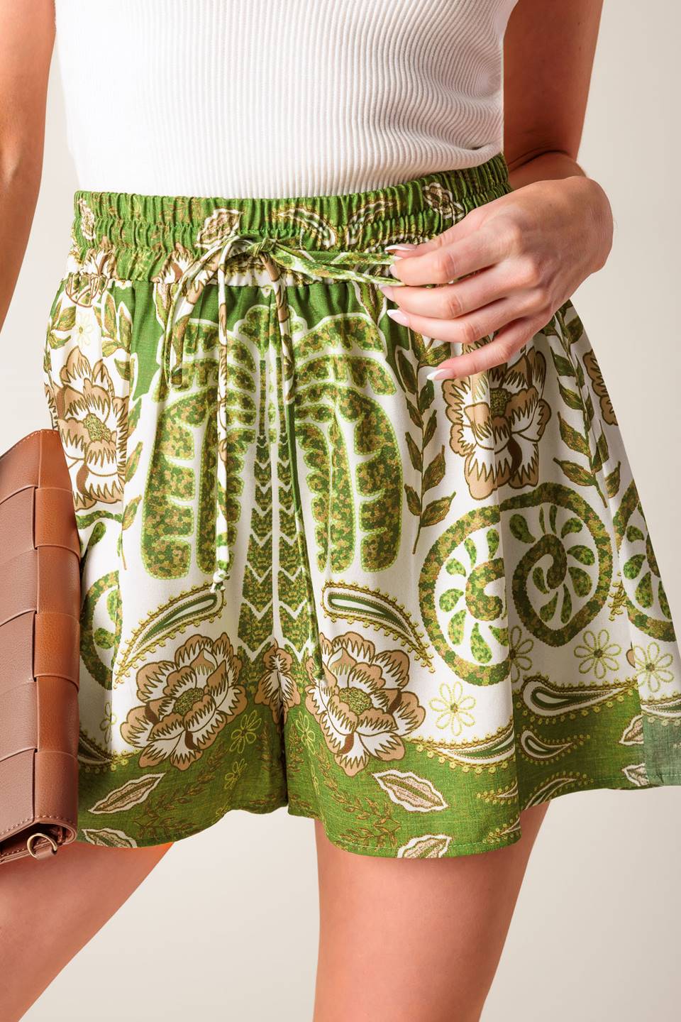 A flowy ivory and green printed short featuring elasticized waistband with front tie.