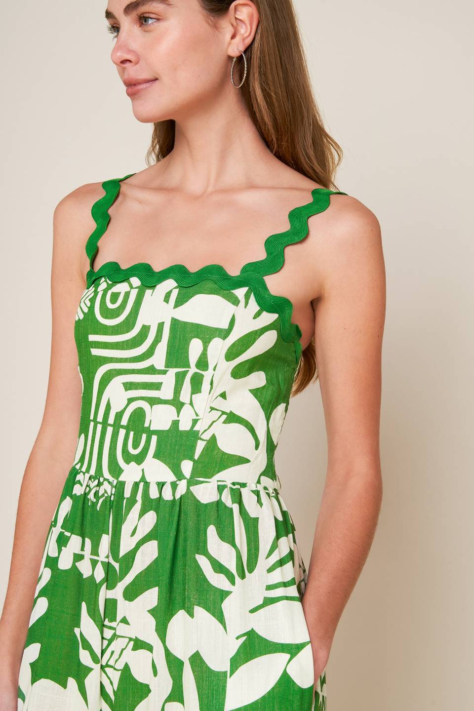 A printed woven jumpsuit featuring straight neckline with ric rac ribbon straps, wide leg and smocked back bodice