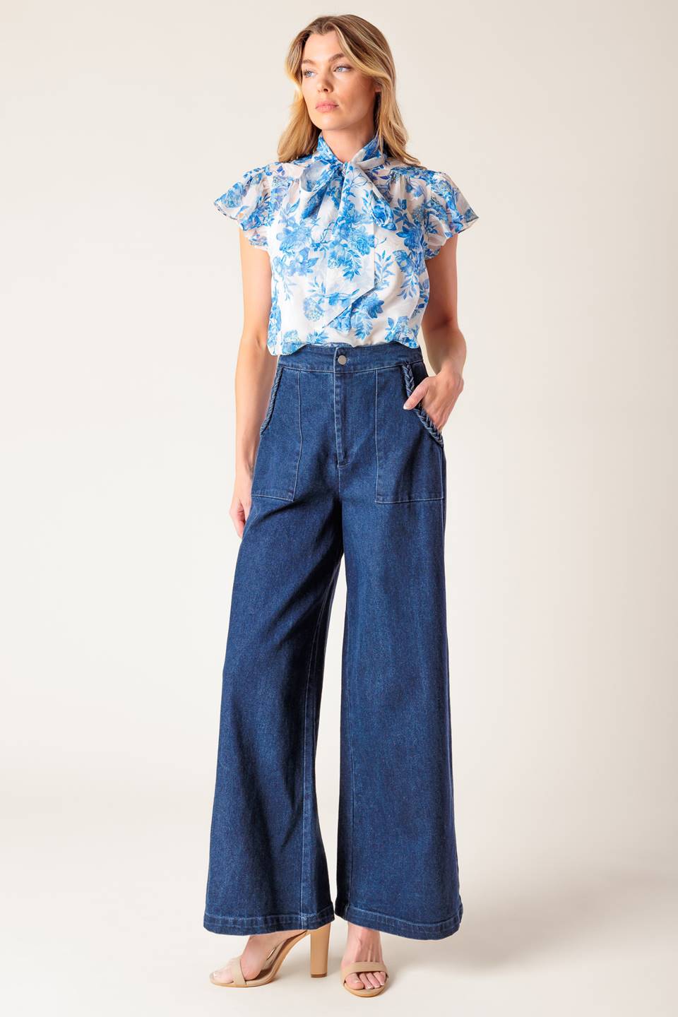 A washed stretch denim pant featuring front closure, braided detail at pocket and wide leg.