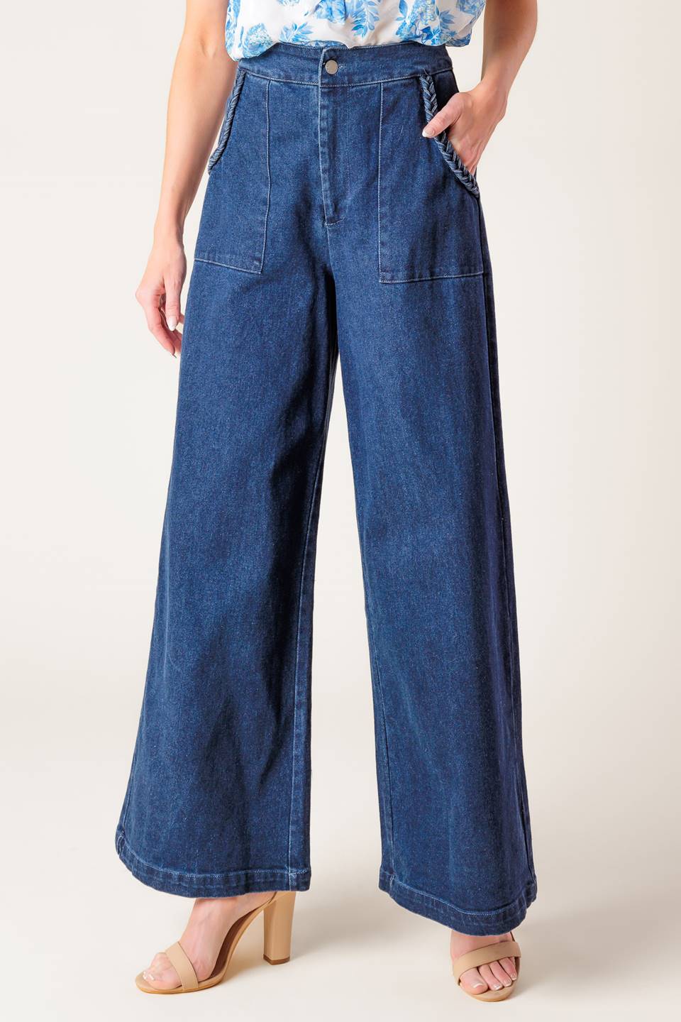 A washed stretch denim pant featuring front closure, braided detail at pocket and wide leg.