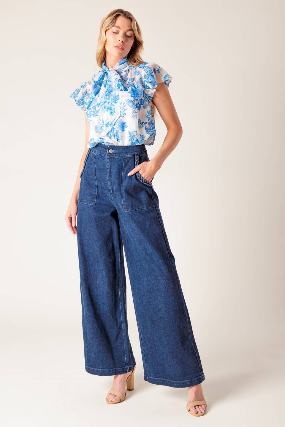 A washed stretch denim pant featuring front closure, braided detail at pocket and wide leg.