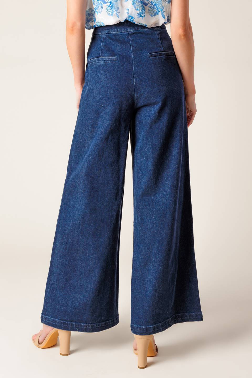 A washed stretch denim pant featuring front closure, braided detail at pocket and wide leg.