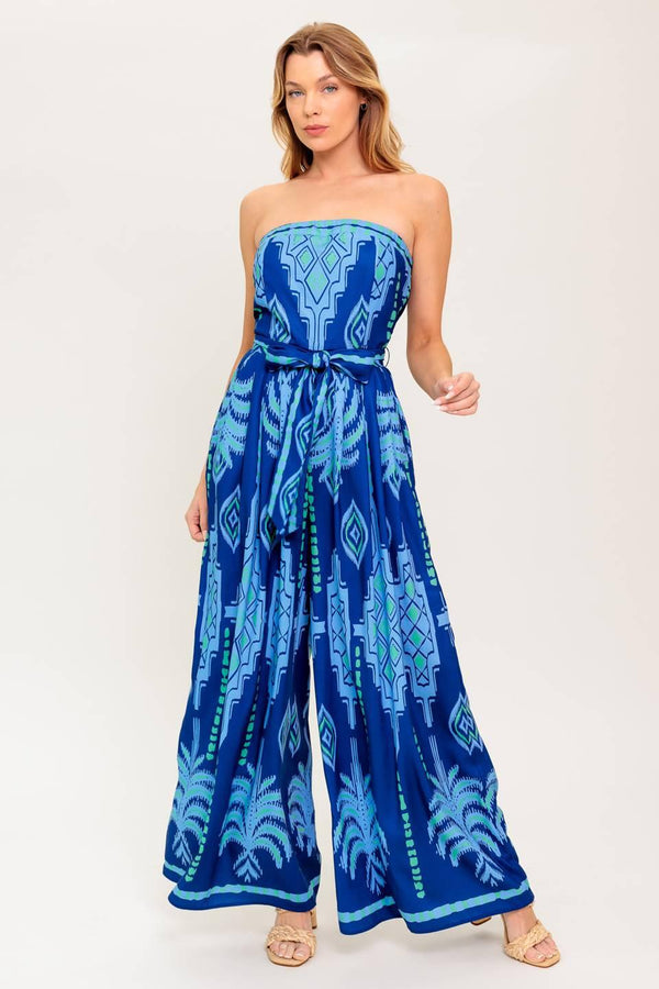 A printed woven jumpsuit featuring strapless, self sash tie, wide leg and back zipper closure
