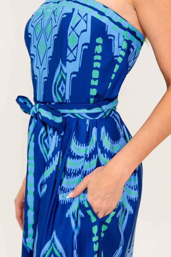 A printed woven jumpsuit featuring strapless, self sash tie, wide leg and back zipper closure