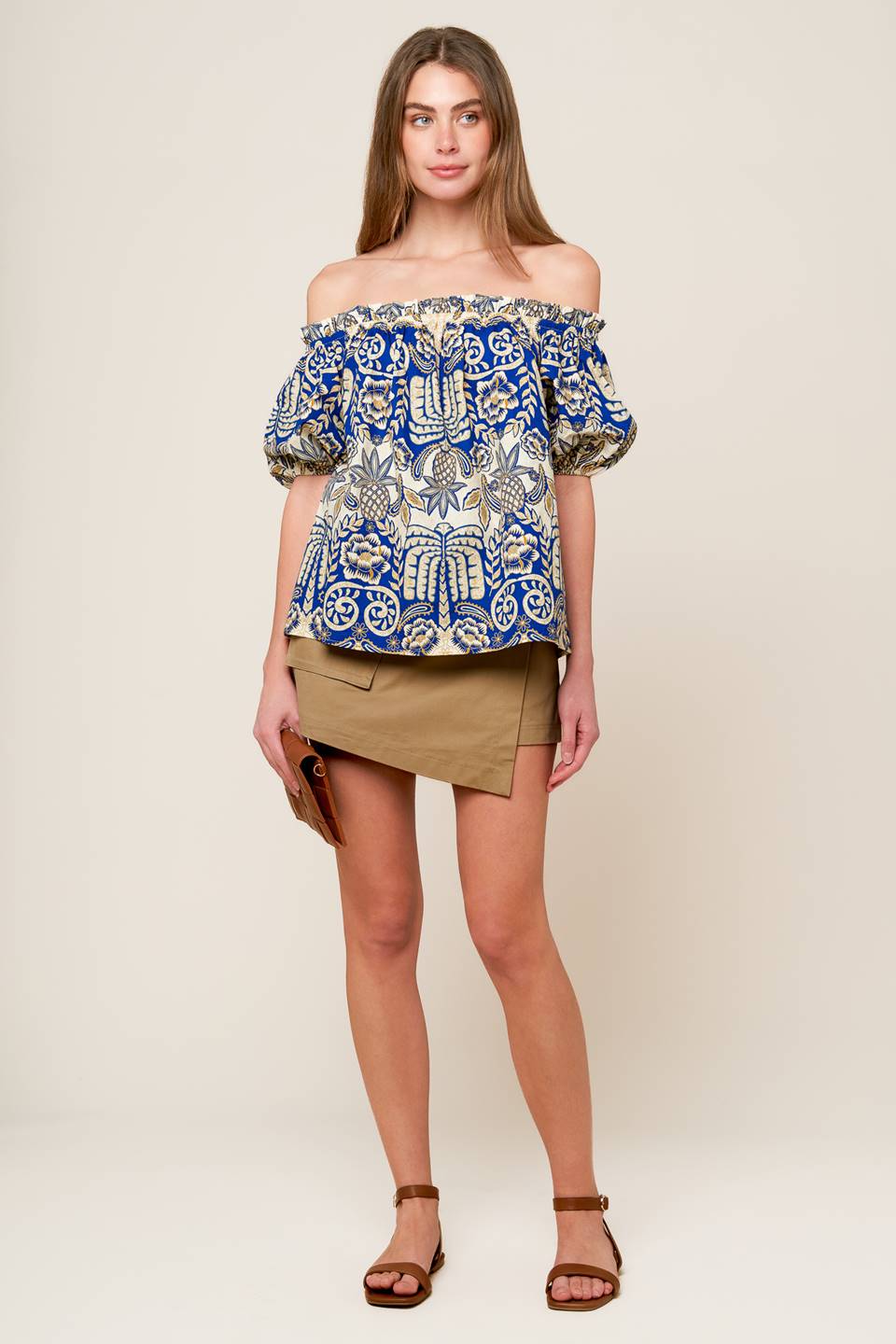 A solid woven tan skort featuring side pocket, self belt and side zipper closure.