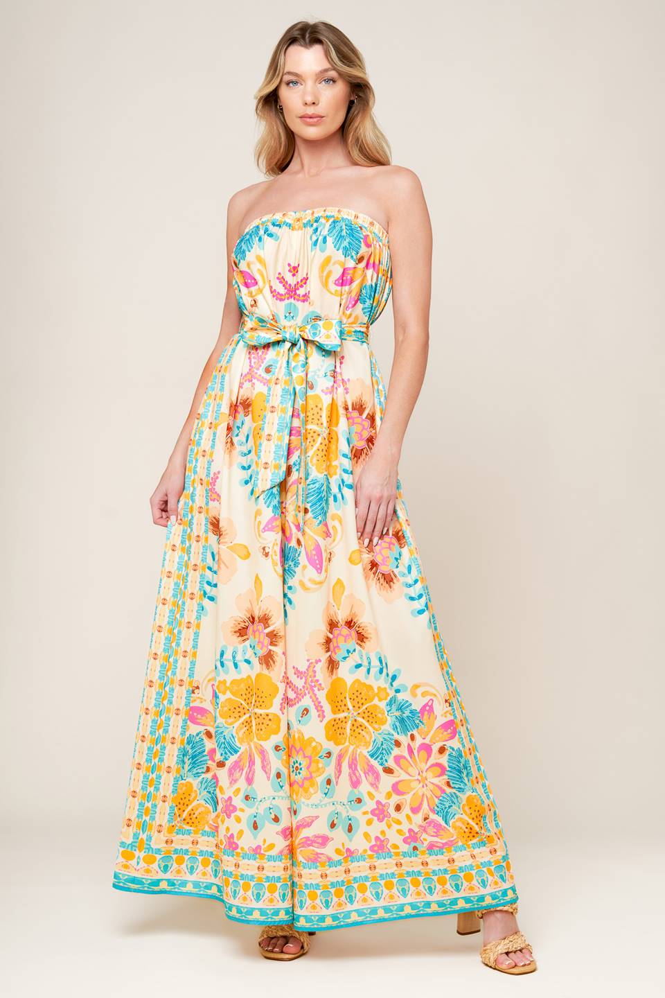 A printed woven jumpsuit featuring strapless, self sash belt and wide leg.