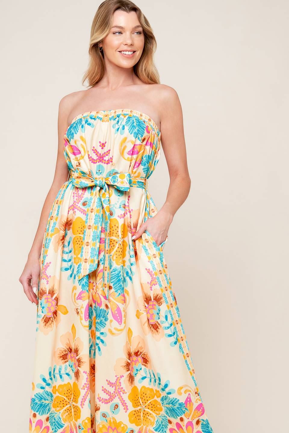 A printed woven jumpsuit featuring strapless, self sash belt and wide leg.