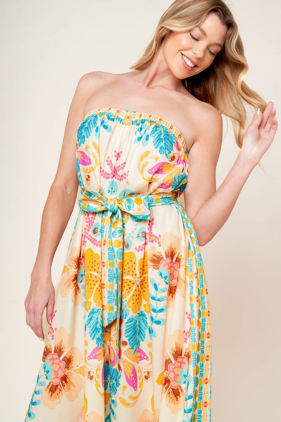 A printed woven jumpsuit featuring strapless, self sash belt and wide leg.