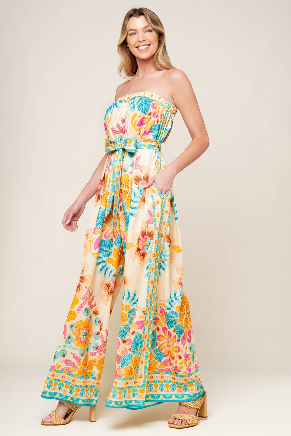 A printed woven jumpsuit featuring strapless, self sash belt and wide leg.