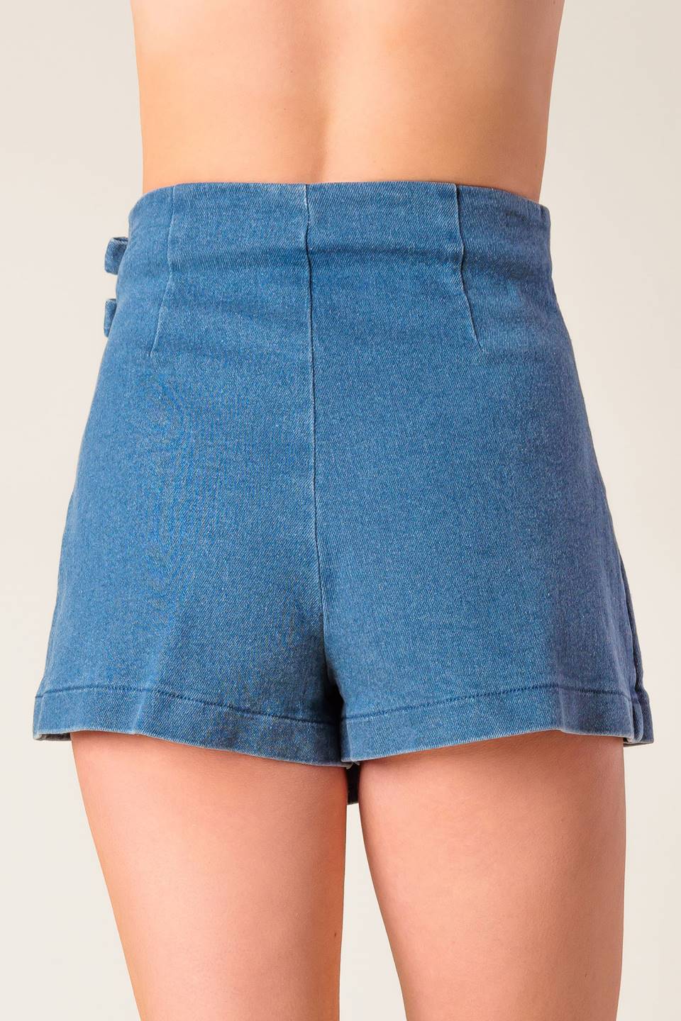 A washed denim mini skort with bow detail and side zipper closure.