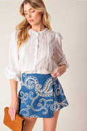 A textured denim woven mini skort with side zipper closure.