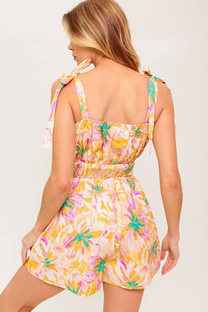 A printed woven romper featuring straight neckline, shoulder tie and smocked waistband