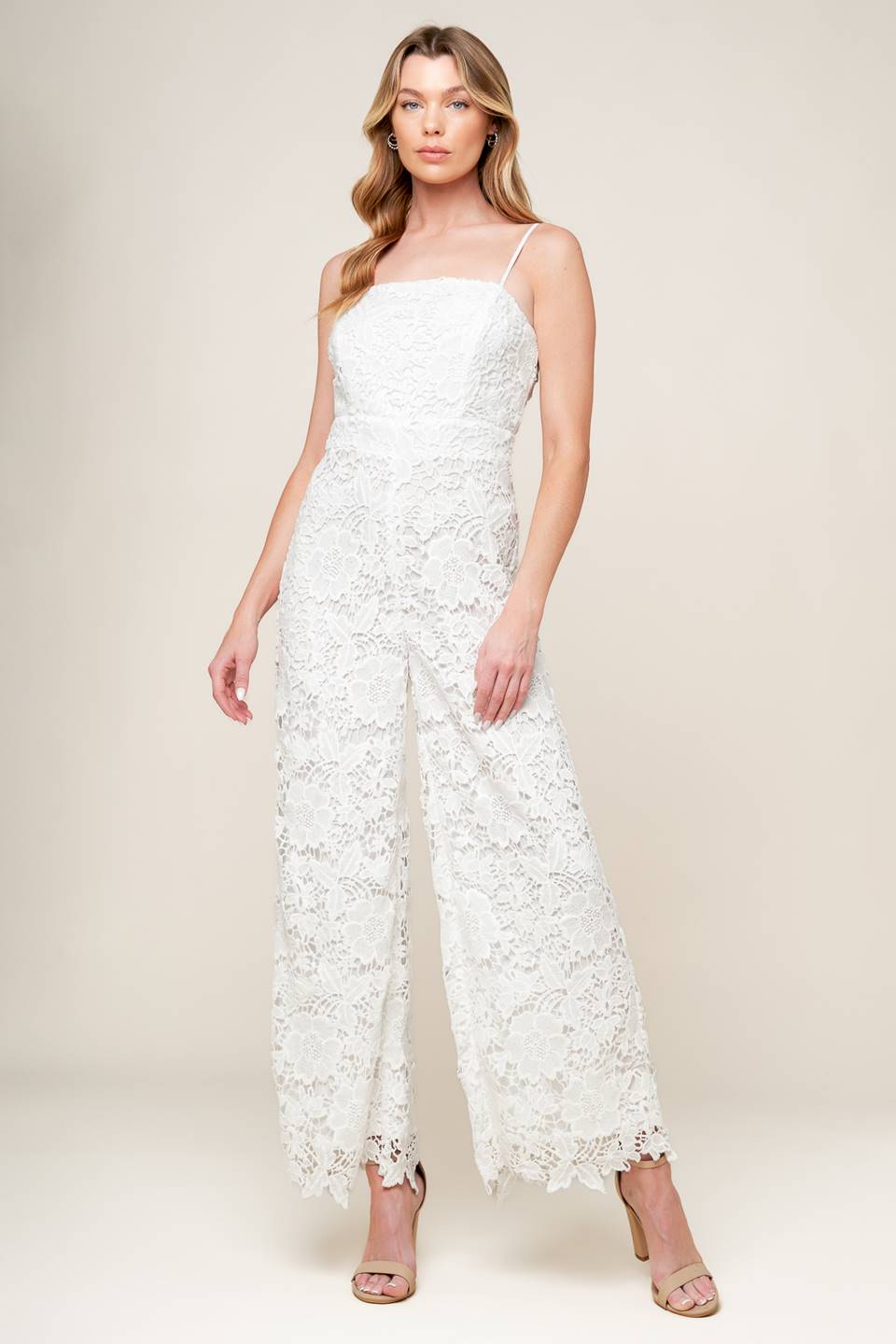 A woven lace jumpsuit featuring straight neckline, cami straps, wide leg and back zipper closure.