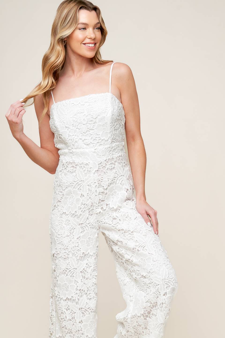 A woven lace jumpsuit featuring straight neckline, cami straps, wide leg and back zipper closure.