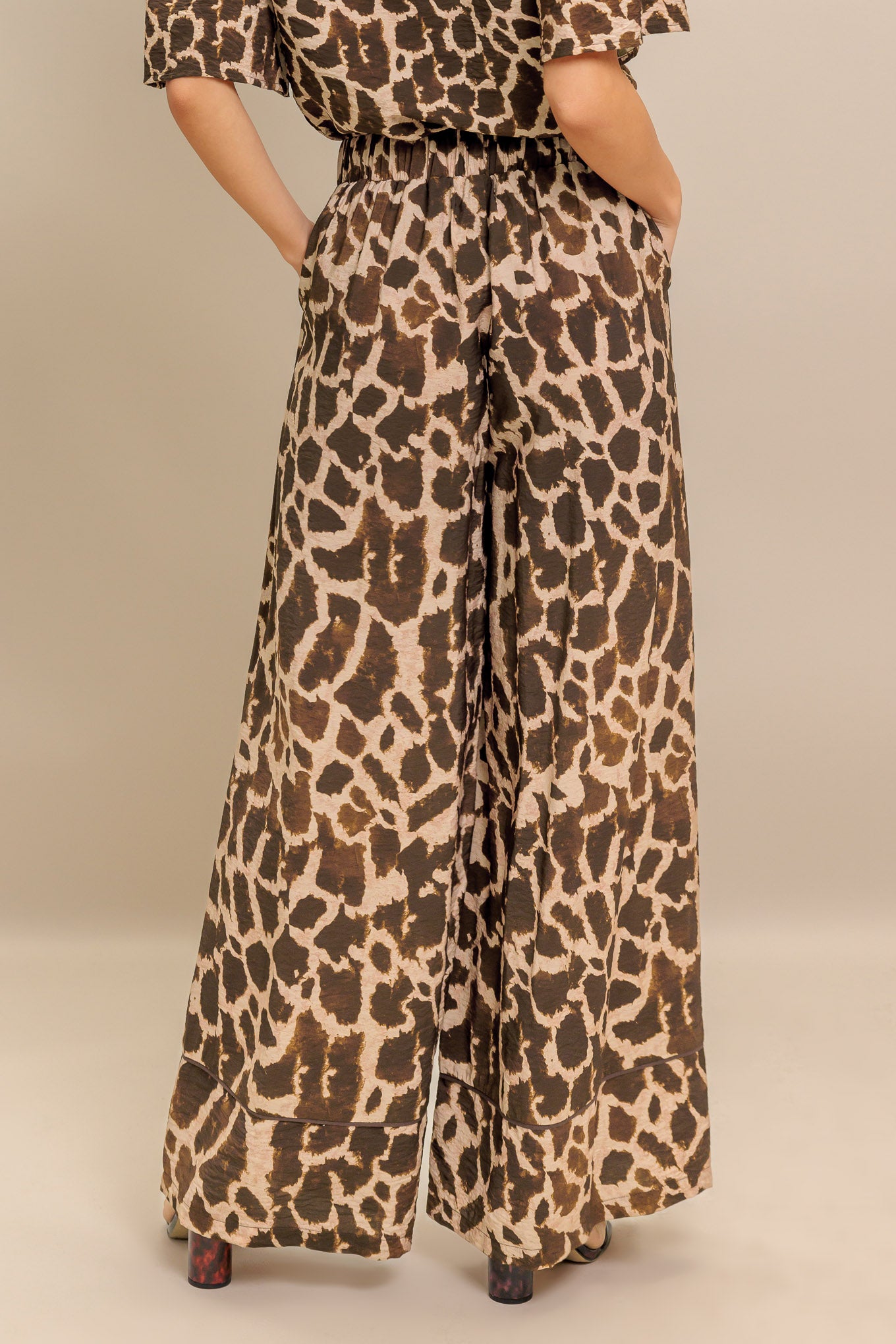 A printed woven pant featuring elasticized waist with front tie and wide leg