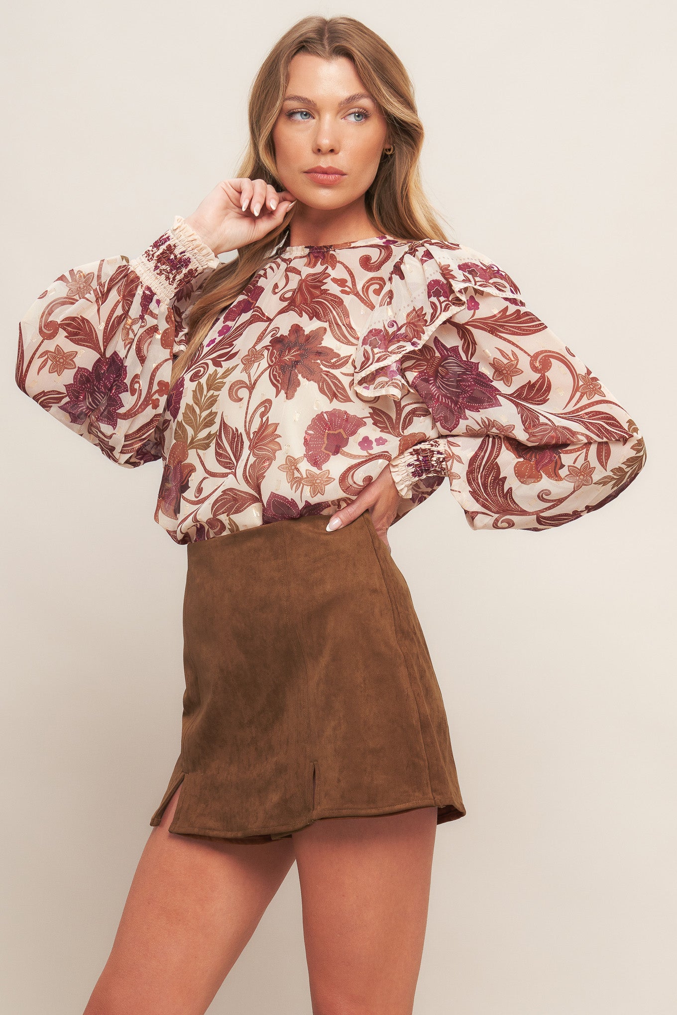 A faux suede skort featuring front slit and back zipper closure