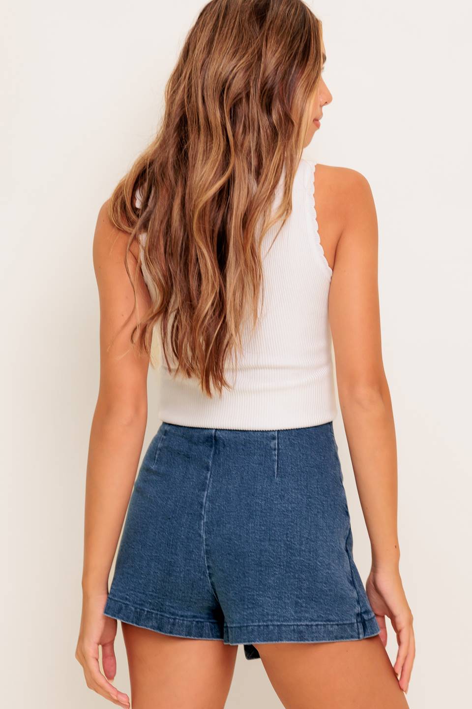 A washed denim skort featuring side buckle detail and zipper closure.