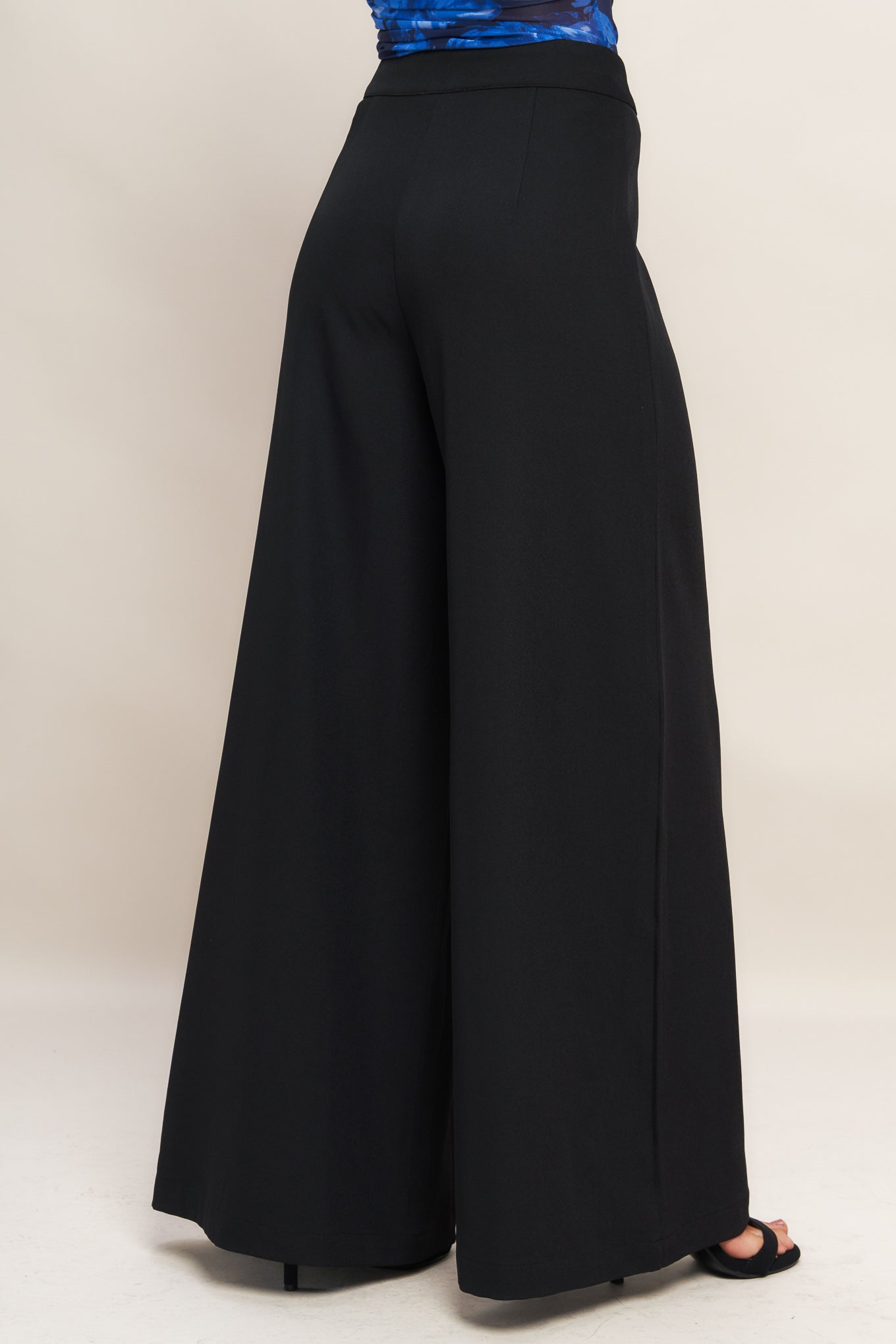 A solid woven wide leg pant with side zipper closure