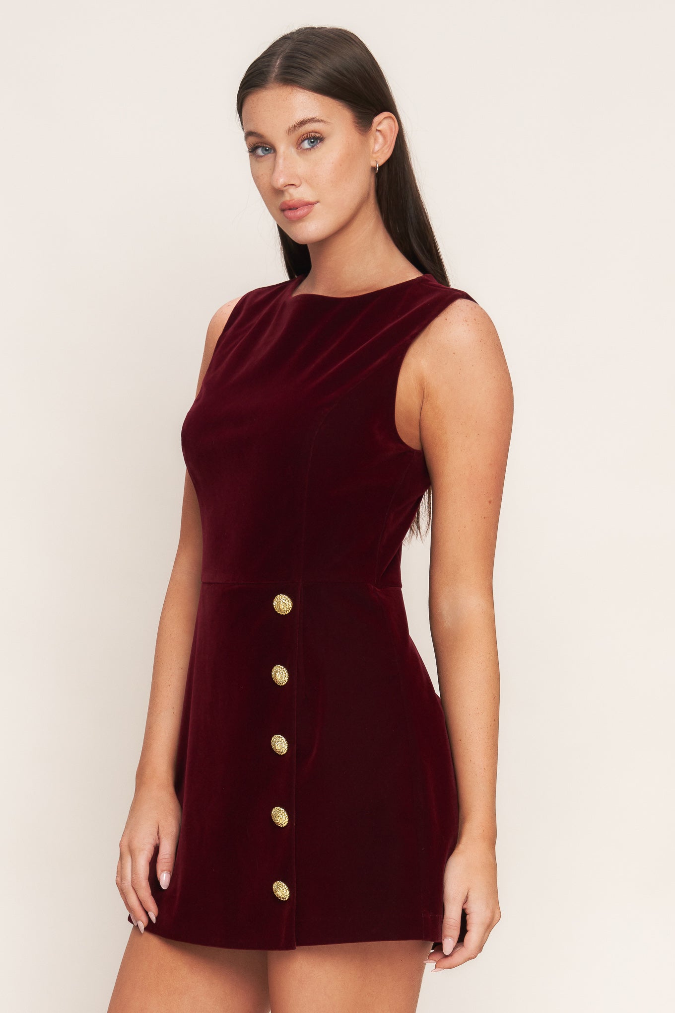 A velvet romper featuring round neckline, sleeveless, skort bottom with button detail and back zipper closure