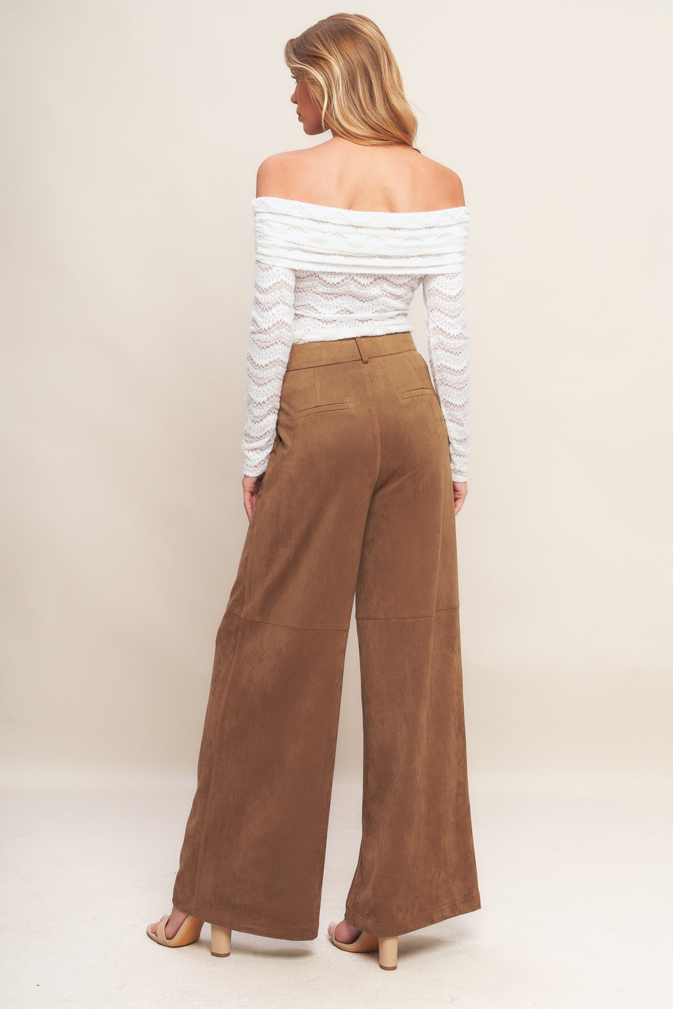 A faux suede pant featuring front closure, side pocket with braided detail and wide leg.