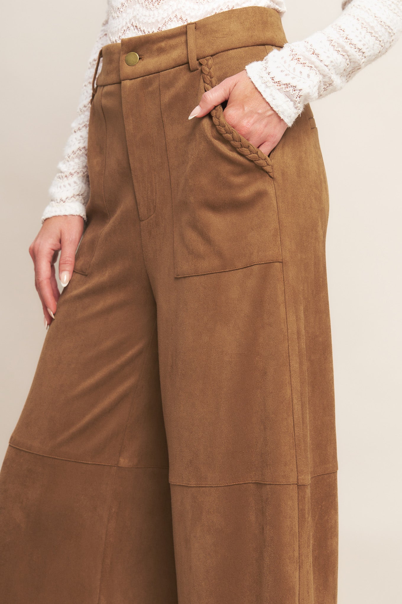 A faux suede pant featuring front closure, side pocket with braided detail and wide leg.