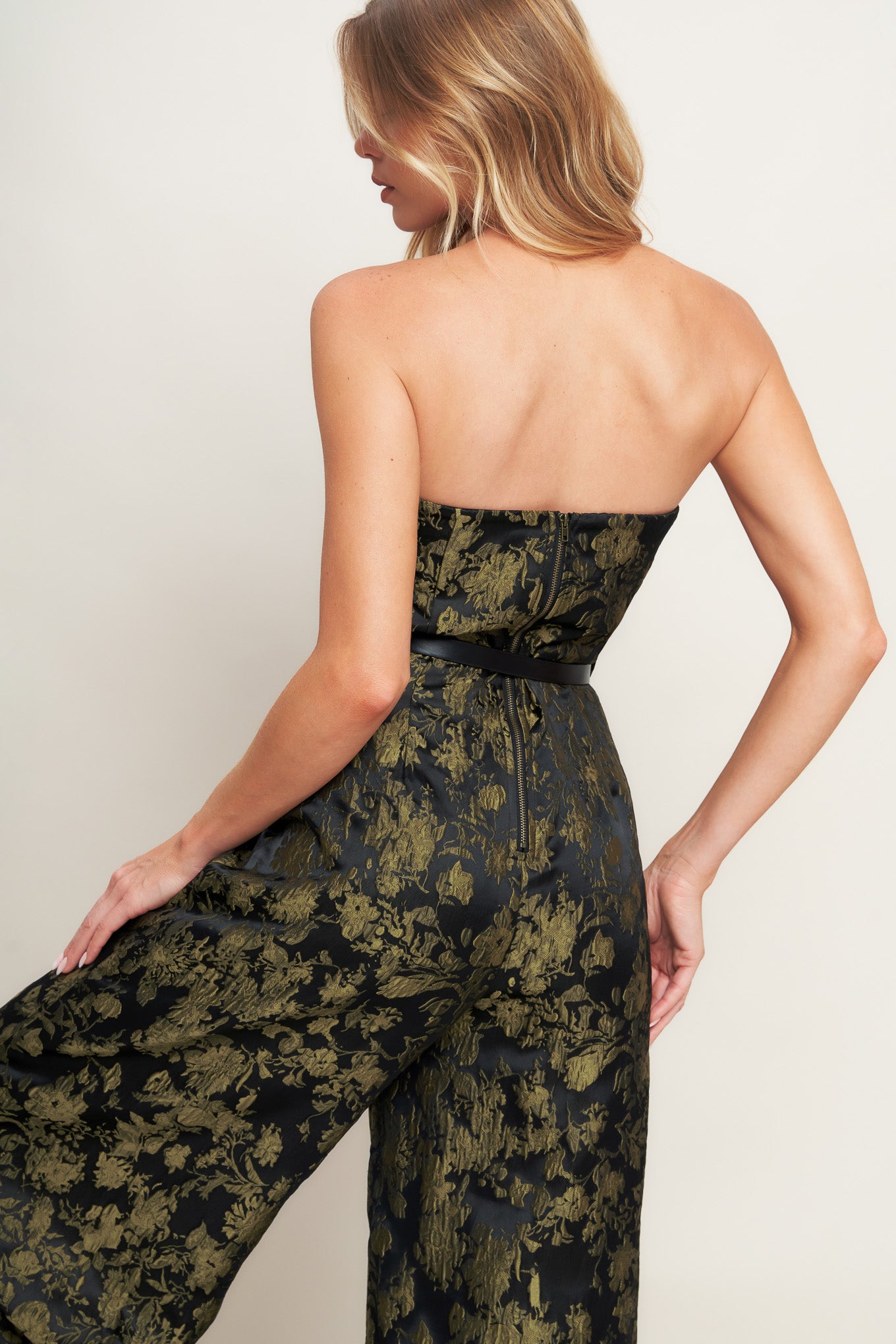 A jacquard woven jumpsuit featuring strapless neckline, contrasting belt, wide leg and back zipper closure
