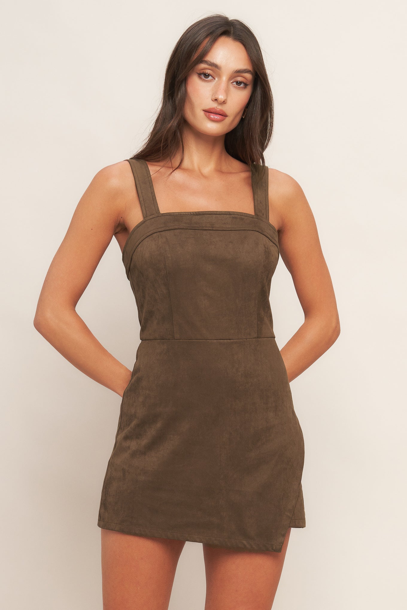 A faux suede romper featuring straight neckline, straps, skort bottom and back zipper closure