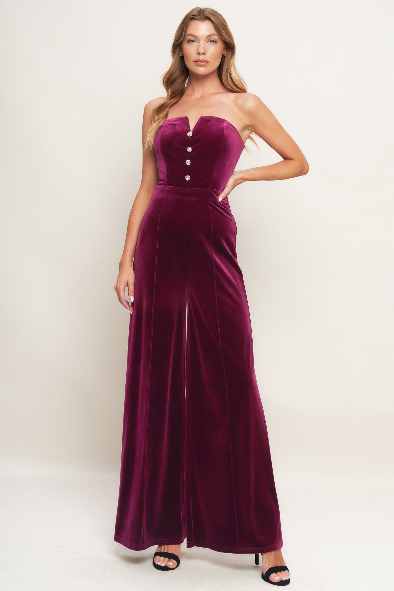 A velvet jumpsuit featuring strapless sweetheart neckline, front button detail, wide leg and back zipper closure