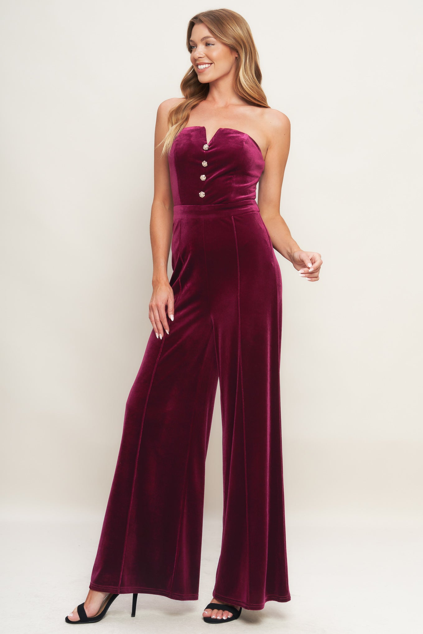 A velvet jumpsuit featuring strapless sweetheart neckline, front button detail, wide leg and back zipper closure