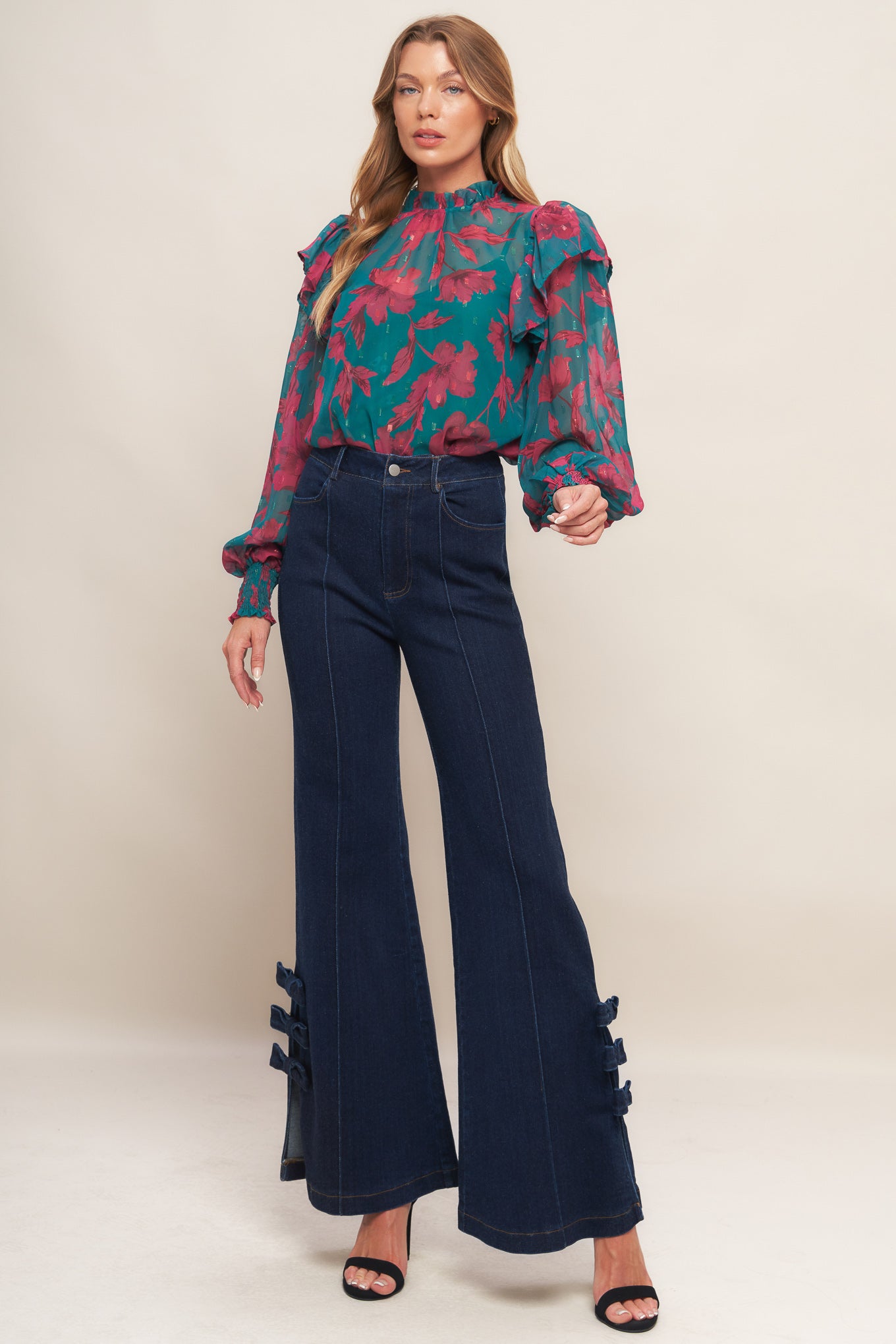A washed denim pant featuring front closure, side pocket, flare leg with bow tie detail